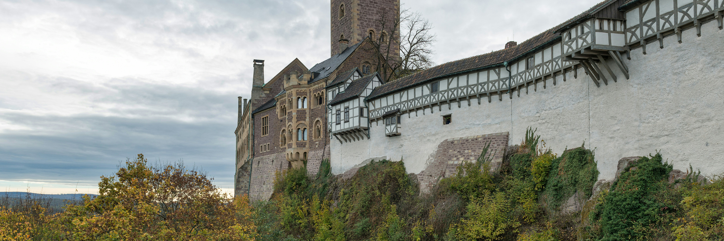 Die Wartburg mit hohen Mauern und einem sie überragenden Turm.
